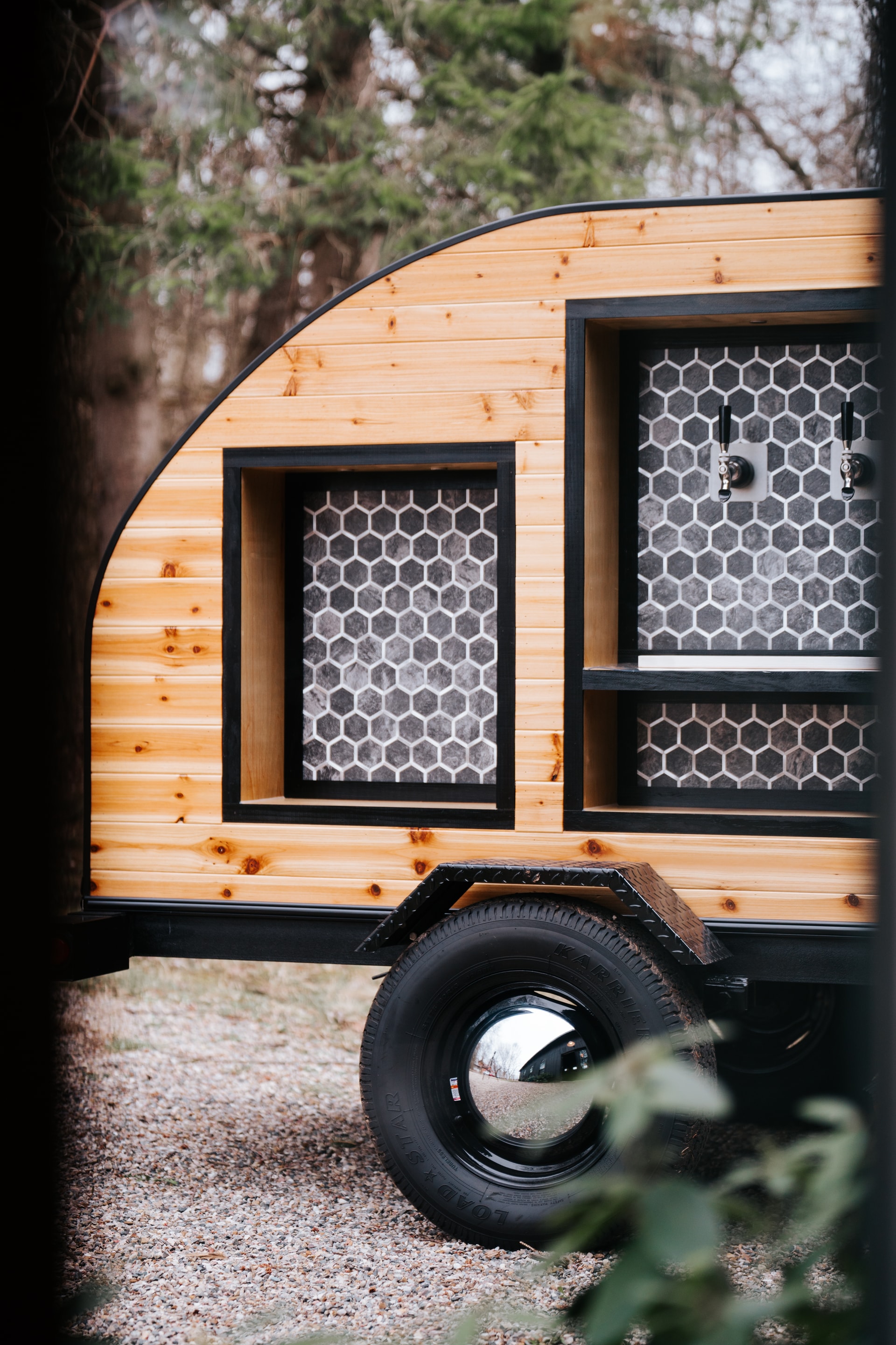 The Tap Wagon cedar trailer set among trees at golden hour